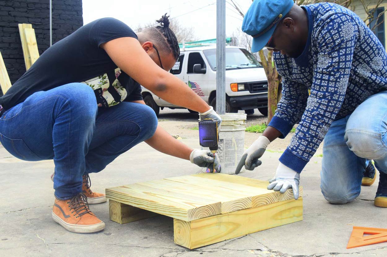 Photo of Blacktocats working together with power tools to improve a community.