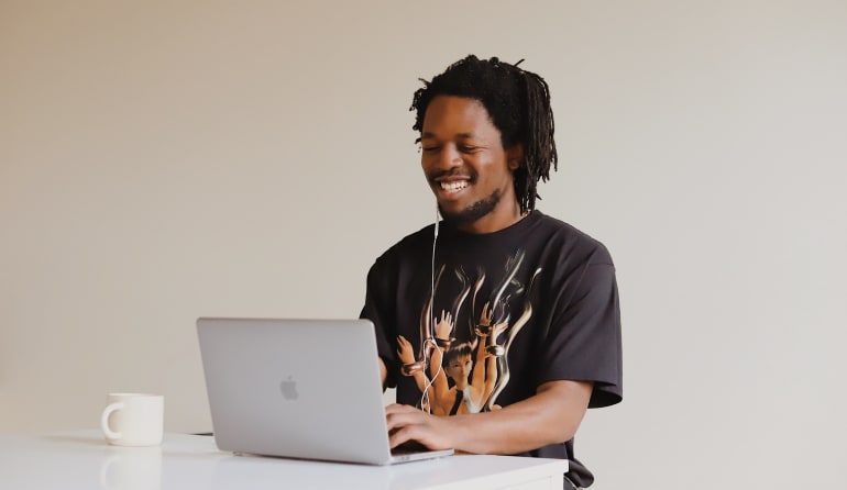  A man working on a laptop at his desk.